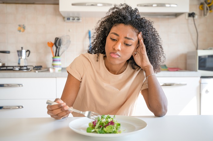 junge Frau isst Salat zum schnellen Abnehmen
