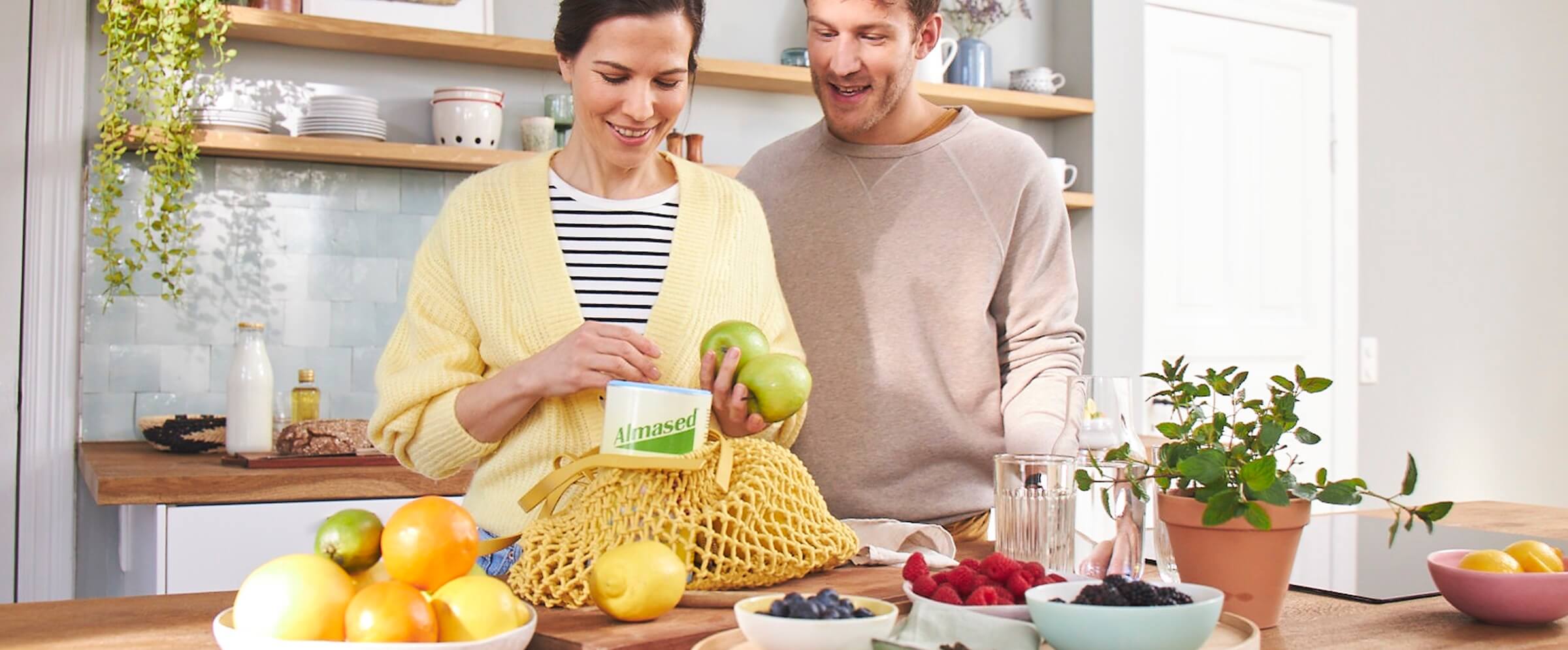 Paar-packt-in-Kueche-Einkauf-mit-Proteinshake-und-anderen-Lebensmitteln-aus