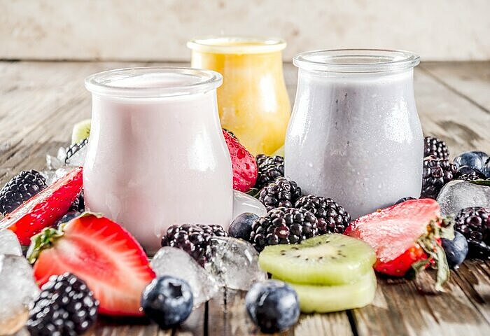 verschiedene-bunte-Proteinshakes-zum-Abnehmen-mit-Fruechten-als-Deko