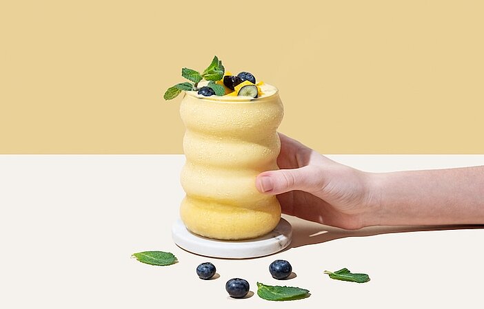 Gelber Abnehmshake im Glas mit Obst Deko