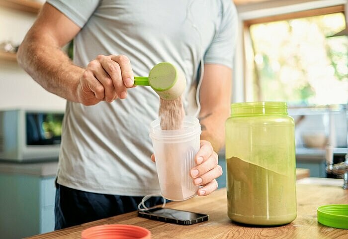 Mann-bereitet-Proteinshake-zum-Abnehmen-mit-Proteinppulver-zu