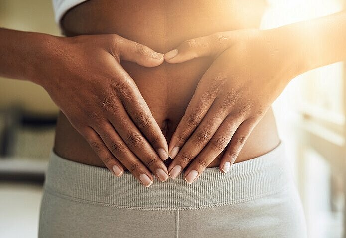 Frau-hält-Hände-auf-Bauch-um-Sättigung-durch-Proteinshakes-darzustellen