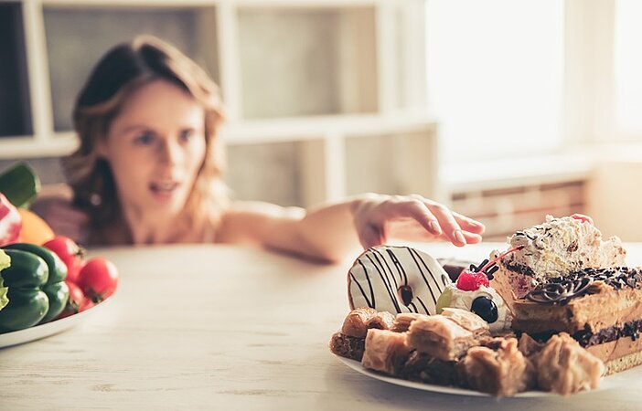 Frau-mit-Heisshunger-greift-nach-Kuchen