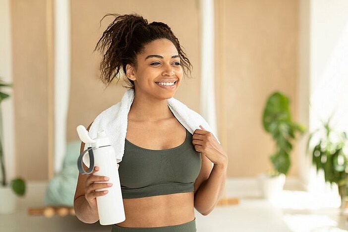 Protein-Shakes-sportliche-lächelnde-Frau-mit-Handtuch